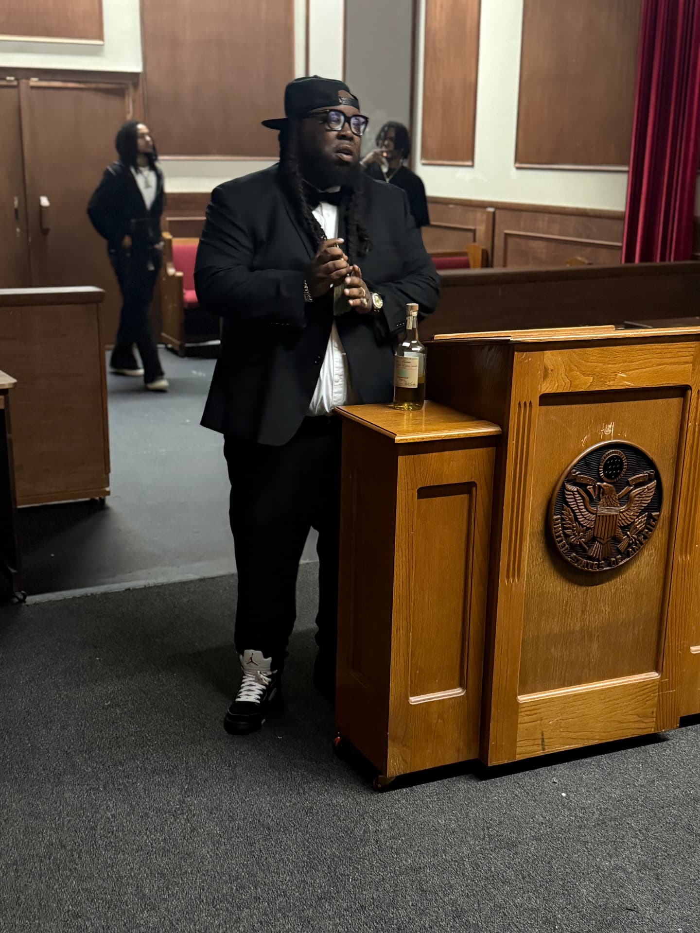 Blockboy Spanky in a tuxedo standing in a courtroom